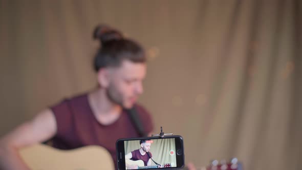 Man Recording Guitar Lessons for Students