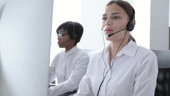 Call Center Agents Consulting Clients On Hotline At Office