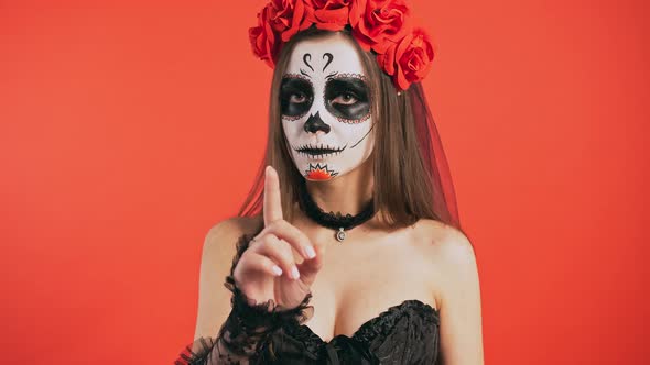 Day of Dead Lady with Sugar Skull Makeup is Showing Prohibiting Hand Gesture No By Forefinger Posing