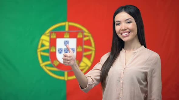 Pretty Woman Showing Thumbs-Up Against Portuguese Flag Background, Migration
