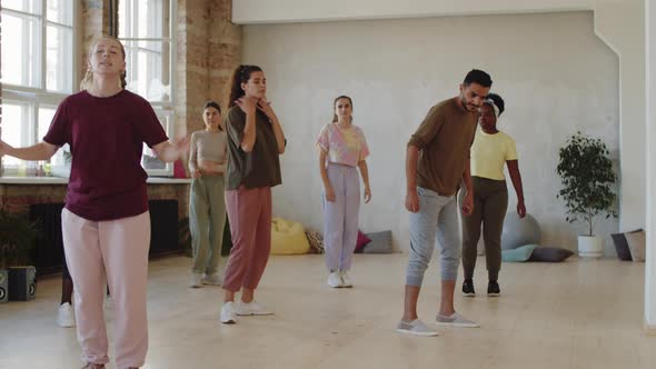 Female Trainer and Group of Multiethnic Students Dancing in Studio