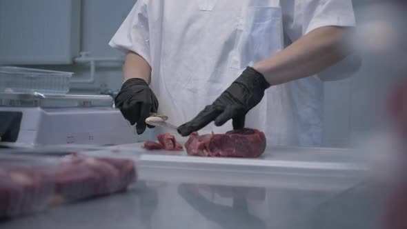 Butcher in Black Proective Gloves Prepares Fresh Meat for Delivery to Stores