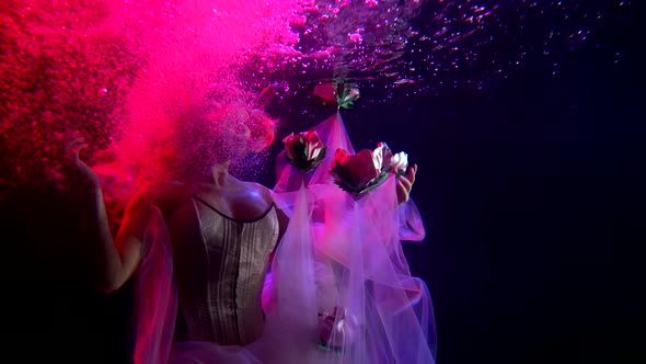 The Girl Princess Is Under Water, She Is Illuminated By Pink Lighting, Her Train Dress and Hair Are