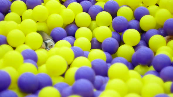 Caucasian boy 8 years old bathes in multi-colored colorful balls in the amusement park.Children's pl