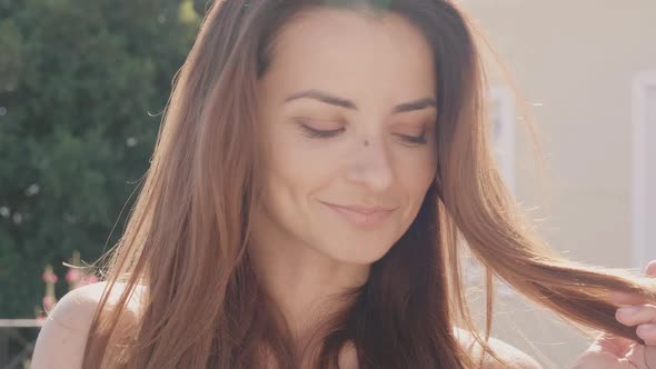 Portrait of beautiful smiling girl posing outdoors at summer sunny day