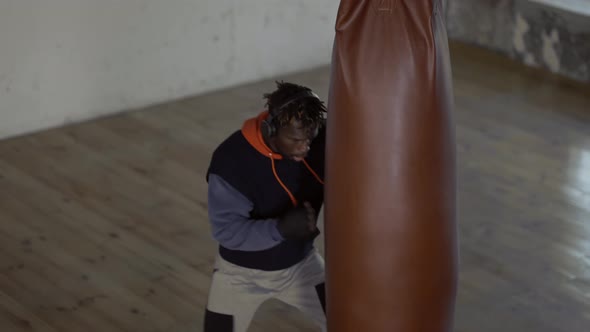 Afro American Boxer Punching the Heavy Bag in the Gym High Angle View