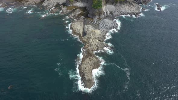 Aerial View of Cape Stolbchaty and Mendeleev Volcano on Background, Kunashir island, Russia.