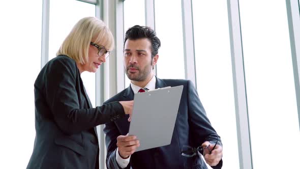 Two Business People Talk Project Strategy at Office