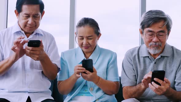 Group of senior friends using smart phone in a retirement home