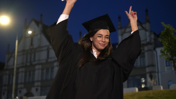 The cute woman graduate dancing.