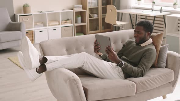 Young Businessman Lying on Sofa while Having Video Call