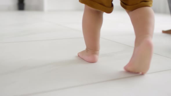 Unrecognizable Baby Walking Barefoot