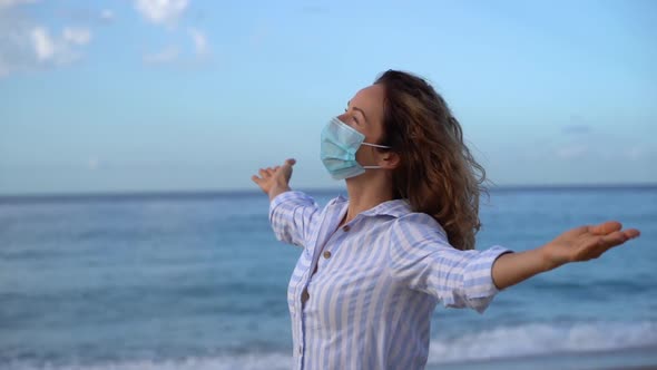 Happy woman wearing medical mask outdoor against blue sky background