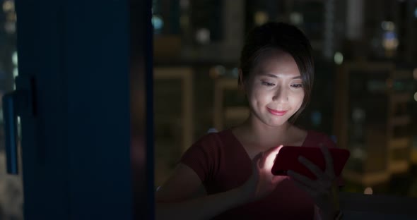 Woman watch on cellphone at home in the evening