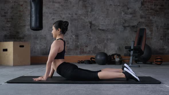 Attractive fit woman stretching in the gym before her workout, female fitness yoga routine concept