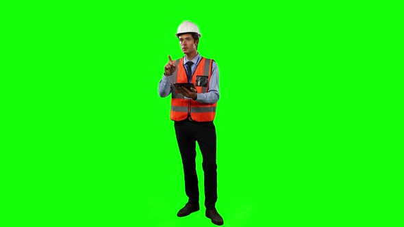 Front view of a site foreman using digital tablet with green screen