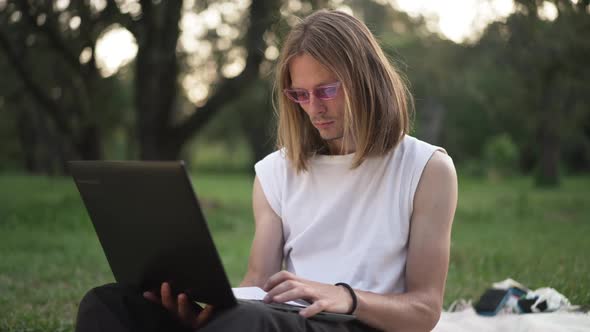 Medium Shot Concentrated Caucasian Young Man Surfing Internet on Laptop Thinking Putting Down