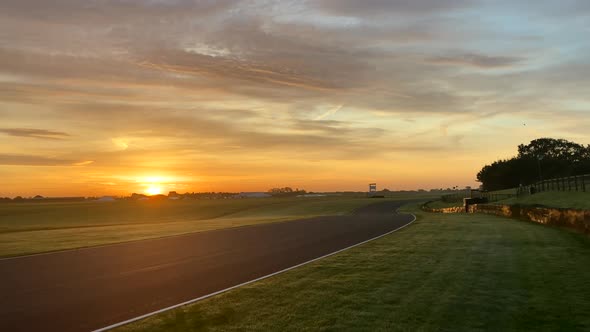 Sunrise shot of a motor race circuit in rural countryside. Camera panning