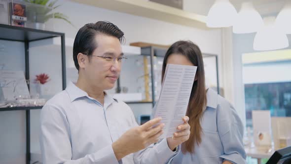 Optical shop concept. Asian couple testing glasses in a shop. 4k Resolution.