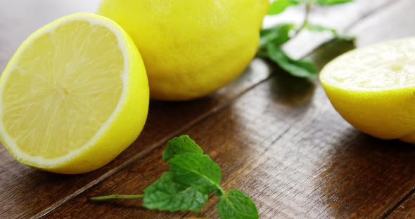 Full and half lemons with mint leaf on table