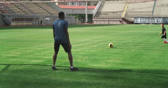 Black Father Trying to Catch Ball From Son During Football Training