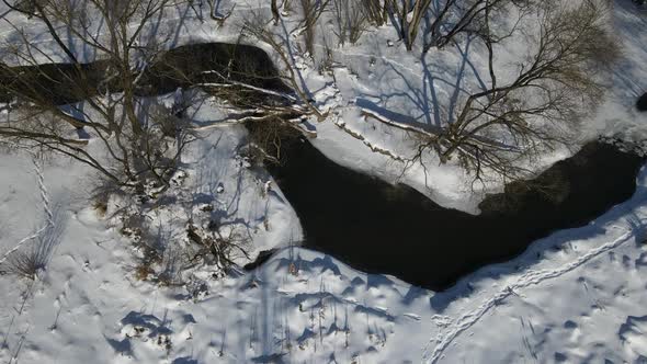 Flight Over The Winter Park. The Drone Flies Over The River.