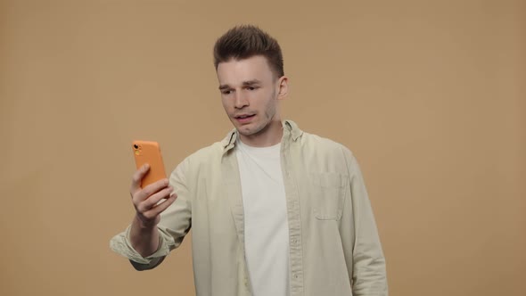 Portrait of Stylish Guy is Talking on a Video Call Using a Smartphone