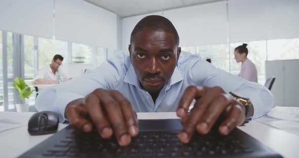 Millennial African American Man Working with Laptop at Modern Corporate Office