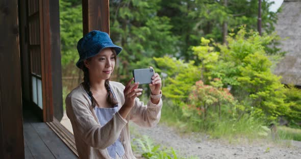 Woman use of cellphone to take photo in Japanese wooden house 