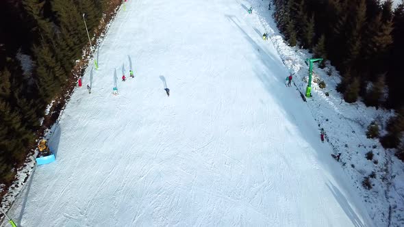 Aerial view of a snowboarder falling down, getting up and continuing to snowboard down slope in Topo