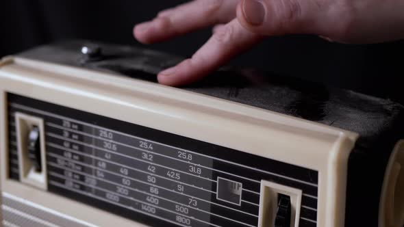 A Female Hand Wipes Dust From the Surface of an Old Receiver with Her Finger