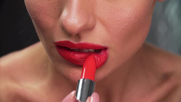 Red Lipstick. Woman Applying Lipstick On Full Sexy Lip Closeup