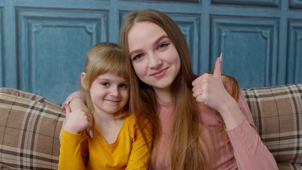 Portrait of Happy Little Child Kid Daughter with Young Mother Hugging Embracing Showing Thumbs Up