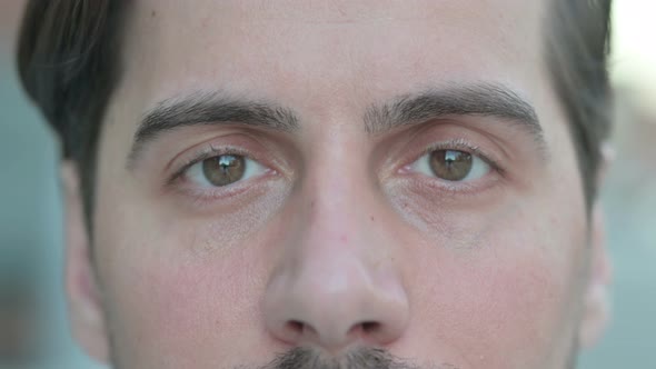 Close Up of Blinking Eyes of Man Looking at Camera