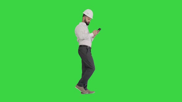 Engineer Walking and Using Smartphone on a Green Screen, Chroma Key