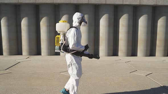 Cleaner with Pressurized Sprayer in Hands Going To Disinfect Public Places