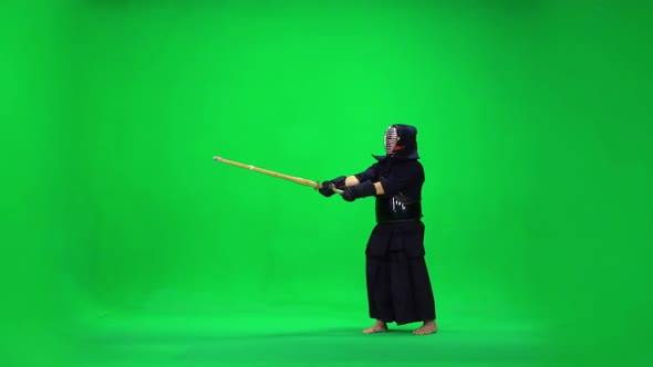 Masculine Kendo Warrior Practicing Martial Art with the Bamboo Bokken on Green Screen. Slow Motion