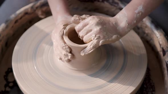 Craft Person Working with Raw and Wet Clay in Workshop Room