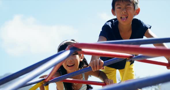 Schoolkids playing on dome climber in playground