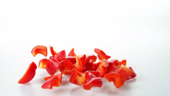 Super Slow Motion Shot of Falling and Slicing Red Pepper on White Background at 1000Fps