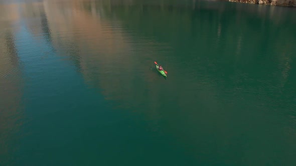 Aerial drone shot following a girl in a kayak in the middle of a strait (Congost de Montrebei) Revea