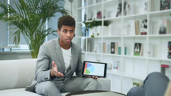 Black Formal Man Making Presentation with Tablet