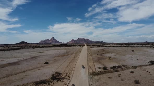 Aerial view on a long dusty road across the desert to the mountains, Namibia