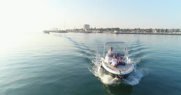 A Drone Shot of a Happy Family on a Summer Vacation Driving a Luxury Boat on the High Seas in the