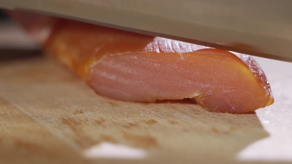 Chef Cuts Pieces of Raw Bacon By Sharp Knife on the Wooden Board