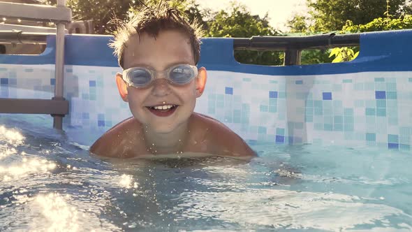 happy baby playing and jumping in the pool in summer