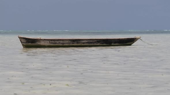 Old Dry African Fishing Rowboat Stranded in Sand on Beach at Low Tide Zanzibar