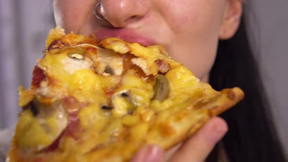 Woman with Piercings Eating Pizza Slices Close Up