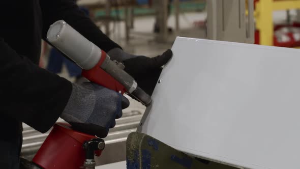 Man Fastens Metal with a Pneumatic Rivet