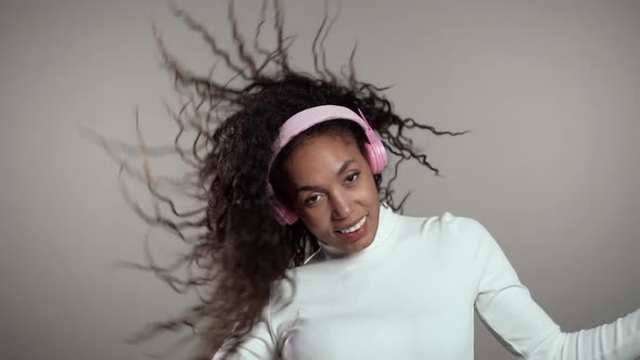 African Woman with Curly Hair Having Fun, Smiling, Dancing with Headphones